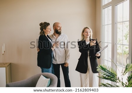 Real estate agent demonstrating a new apartment to a happy couple. Buying a property. Royalty-Free Stock Photo #2162809403