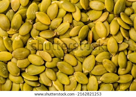 Pumpkin seeds peeled, close-up on a white background. Healthy seeds and nuts.