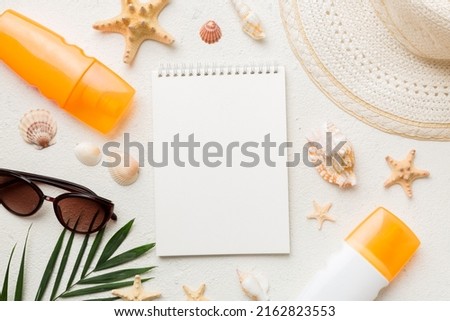 Blank writing book with summer beach accessories on background, copy space. Flat lay with copy space. Royalty-Free Stock Photo #2162823553
