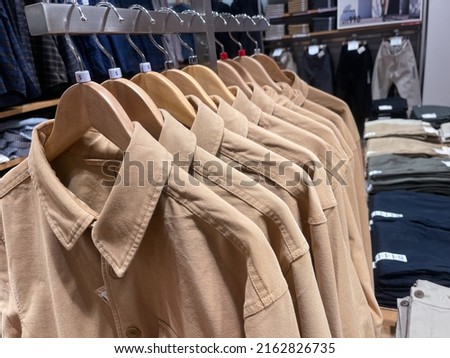 different clothes ,dress, shirt ,sweater, suit ,jacket ,jeans on hangers in store.