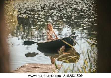 Joyful Caucasian lady boating along the river