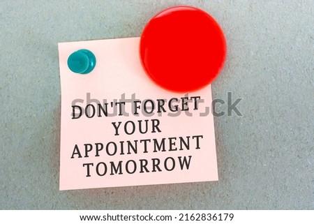 Text on sticky notes with red smile face magnet - Don't forget your appointment tomorrow.