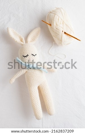 Cute handmade crochet knitted amigurumi bunny with a blue scarf