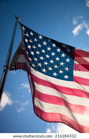 United States flag blows in the wind against a blue sky on a sunny day