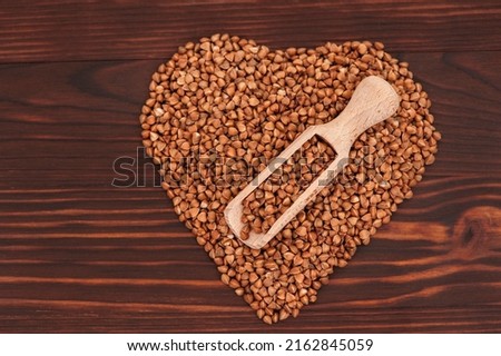 Raw and fresh buckwheat grain on wooden background from above, with copy space for text.