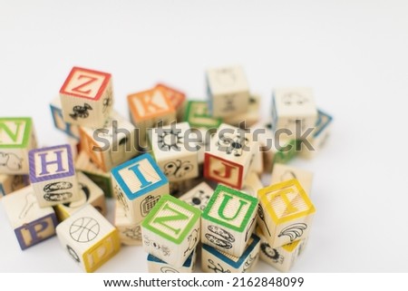 A pile of children painted alphabet wooden blocks isolated with white background for text copy space.