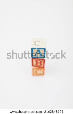 A stack of children painted alphabet wooden blocks isolated with a white background for text copy space.