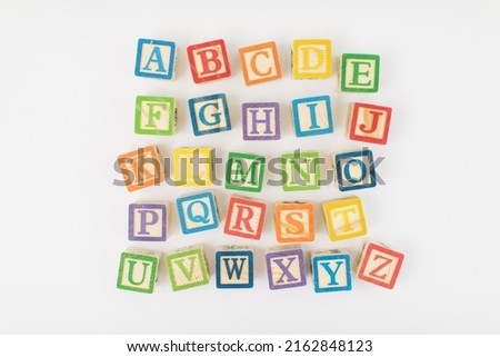 An arrangement of children painted alphabet wooden blocks isolated with white background for text copy space.