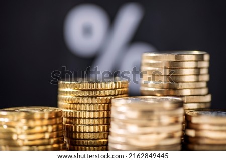 Stack with coins and percent sign in background