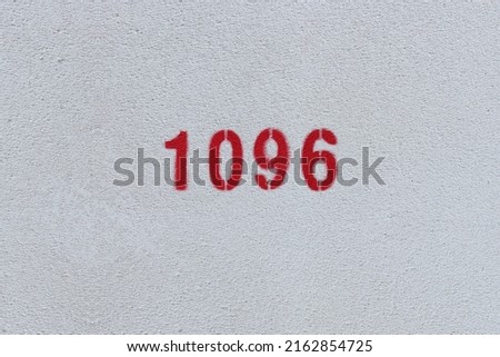 Red Number 1096 on the white wall. Spray paint.
