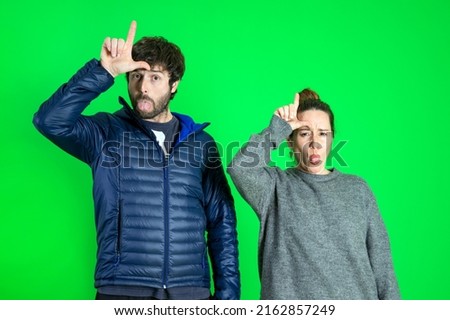 Young beautiful couple with lol message pointing, hand sign