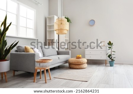 Interior of modern living room with comfortable sofa and lamp