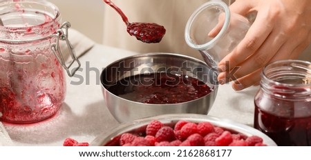Woman making sweet raspberry jam, closeup Royalty-Free Stock Photo #2162868177
