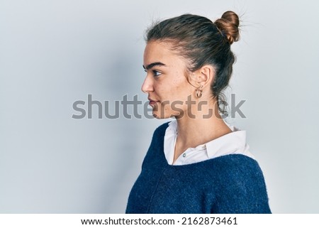 Young caucasian girl wearing casual clothes looking to side, relax profile pose with natural face with confident smile. 