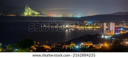 night landscape with the famous rock of gibraltar in the background and several towns in front, highlighting a block of buildings