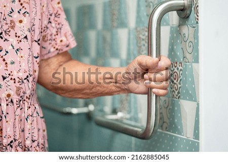 Asian senior or elderly old lady woman patient use toilet bathroom handle security in nursing hospital ward, healthy strong medical concept. Royalty-Free Stock Photo #2162885045