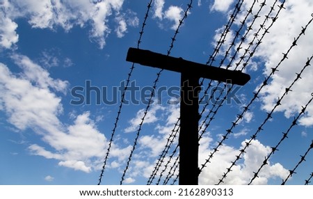 Сontour of barbed wire on background beautiful clouds and sky 