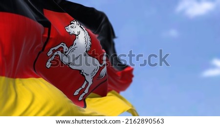The flag of Lower Saxony waving in the wind on a clear day. Lower Saxony is a German state (Land) situated in northwestern Germany Royalty-Free Stock Photo #2162890563