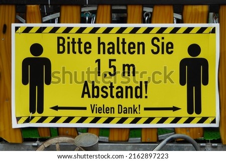 German yellow info sign "Bitte halten Sie 1,5 m Abstand! Vielen Dank!" translates to "Please keep a distance of 1.5 m! Thanks very much!" pandemic info statement . Funny quote during corona pandemic .