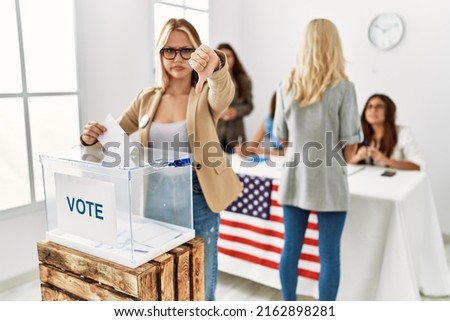 Group of young girls voting at democracy referendum looking unhappy and angry showing rejection and negative with thumbs down gesture. bad expression. 