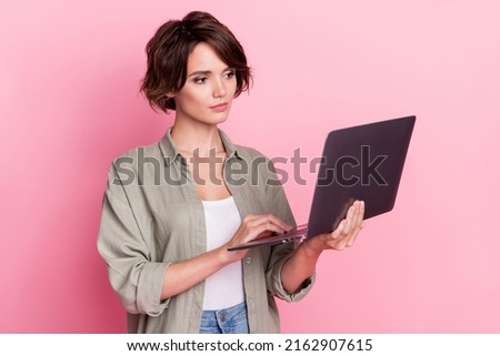 Photo of serious calm person hold use netbook wear khaki shirt isolated on pink color background
