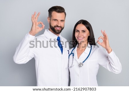 Portrait of two professional docs show okey symbol wear white coat isolated on grey color background Royalty-Free Stock Photo #2162907803