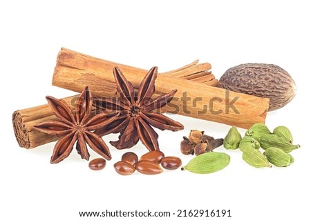Various spices - cinnamon sticks, star anise, cloves, nutmeg and cardamom pods isolated on a white background.