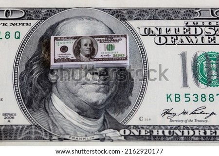 bundles of miniature 100 dollar banknotes on 100 dollar banknote background for design purpose