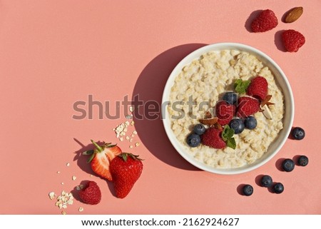 Oatmeal porridge with fresh berries. National Porridge Day, banner. Creative flt layot.