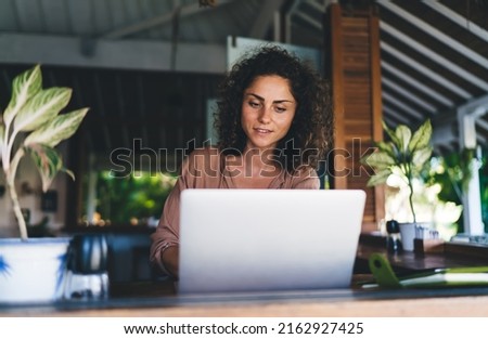 Millennial female blogger using laptop application for communicate with web followers in social media networks, skilled Caucasian woman connecting to 4g wireless internet on modern netbook computer