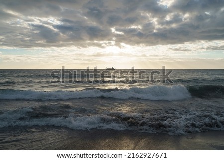 Photography of sea in summer day. Touristic boat in distance. Travel concept. Beautiful blue landscape. Sun in clouds. Golden sunlight and blue sea and sky. Cruise fun. Panoramic. Perspective
