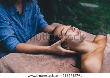 Young woman doing Thai massage for stretch skin during therapy procedures - concept of serene spa treatments, Asian female enjoying sunday for dayspa with professional cosmetologist and masseur