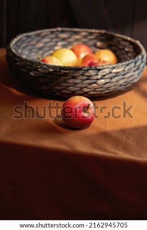 Apple and basket on a table with shadows