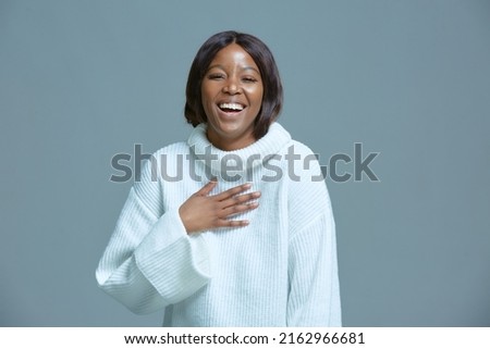 Joyful african american woman laughing at joke. Black girl giggle holding hand on chest. Candid positive emotions, humor