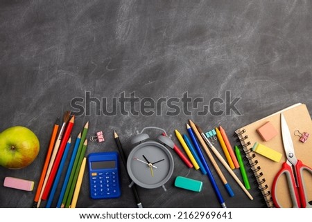 Back To School and education Concept. Alarm clock, chalk and over supplies on blackboard background. Copy Space, top view flat lay
