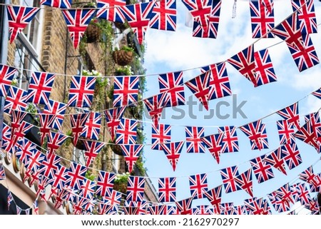 Union Jack flags on the street during queens jubilee celebration. Street party decorations in the UK city. Selective focus  Royalty-Free Stock Photo #2162970297