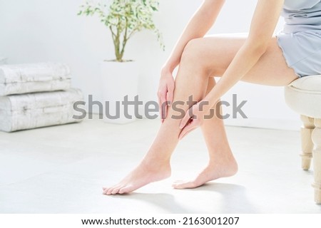 Asian woman taking car of her leg at home, no face Royalty-Free Stock Photo #2163001207