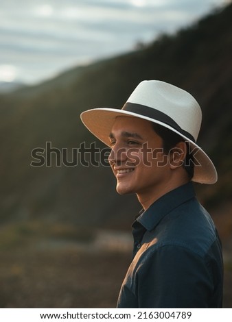 young man on vacation in the ecuadorian highlands smiles wearing his toquilla straw hat, the panama hat, made in Montecristi - ecuador Royalty-Free Stock Photo #2163004789