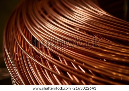 Large bobbin of orange copper wire in light warehouse Royalty-Free Stock Photo #2163022641