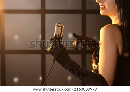 Female singer with microphone performing on stage, closeup