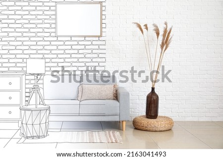 Sofa, table and vase in light living room with brick wall. Interior design
