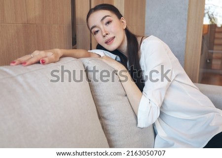 Portrait picture of Young Caucasian woman smile relax before sleep on sofa bed