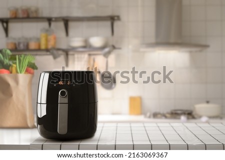 Air fryer machine cooking potato fried in kitchen. Lifestyle of new normal cooking. Royalty-Free Stock Photo #2163069367