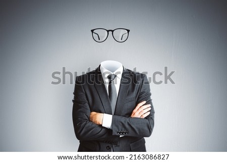 Headless invisible businessman in suit with folded arms and abstract glasses standing on gray wall background. Business and secret concept Royalty-Free Stock Photo #2163086827