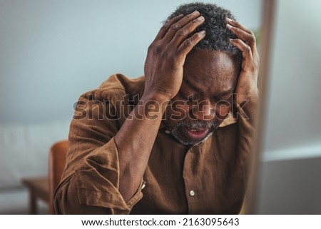 Stressed elderly grey-haired man in glasses look at laptop screen have problems paying bills taxes online. Thoughtful mature 70s male manage household finances, calculate expenses expenditures at home Royalty-Free Stock Photo #2163095643