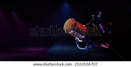 microphone on stage in neon lights. live performance, karaoke and music concert background. copy space Royalty-Free Stock Photo #2163106707