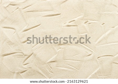 Natural fine sand stone texture as background. Top view sand texture, sandy beach backdrop. Sunlight and hard shadows, summer sunny day, natural textured surface.