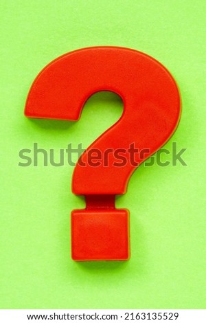 Red plastic question mark on the green background