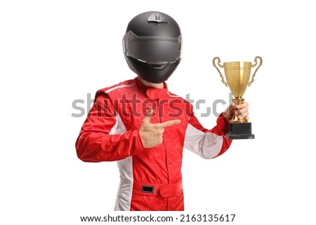 Car racer winner with a black helmet holding a gold trophy cup and pointing at it isolated on white background Royalty-Free Stock Photo #2163135617