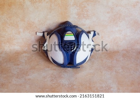 High angle shot of a half-face mask with filters on a studio background. Protective equipment and industry.